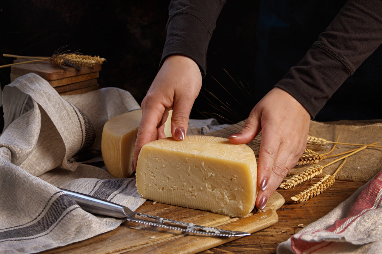 mujer enseña un queso fabricado artesanalmente