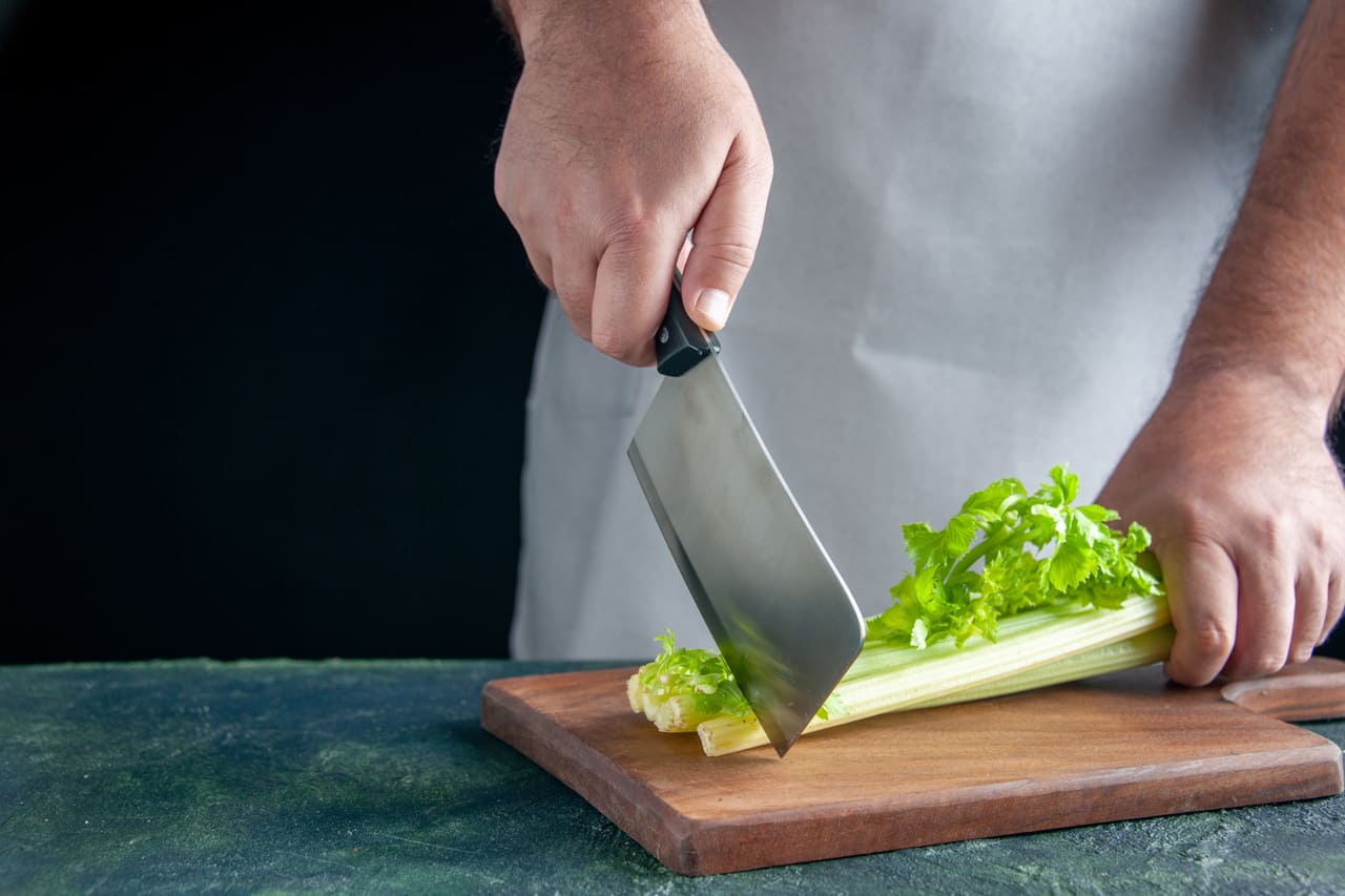 cocinero cortando verduras con mejores juegos de cuchillos de cocina