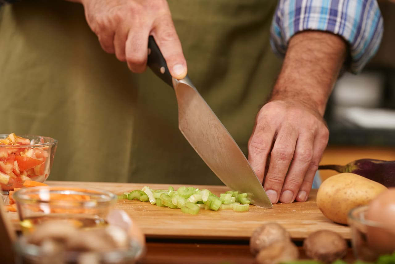 cocinero cortando verduras con mejores juegos de cuchillos de cocina