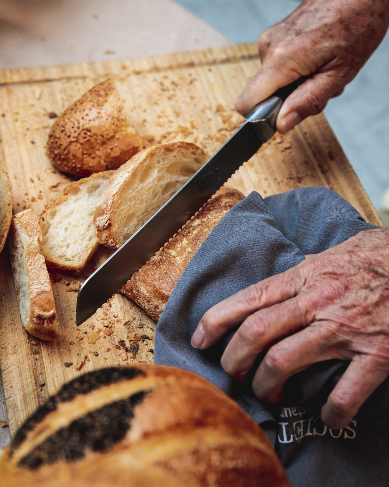 cocinero cortando pan con mejores juegos de cuchillos de cocina