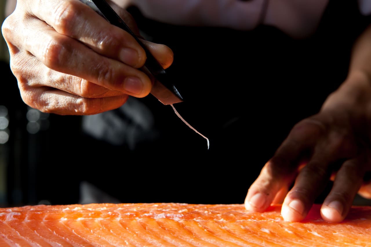 Cocinero preparando un Salmón hacer sushi